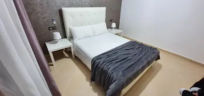 a small bedroom with a bed and a side table at Villa Nour in Fès