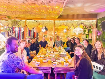 a group of people sitting around a table in a restaurant at Riad Verus in Fès