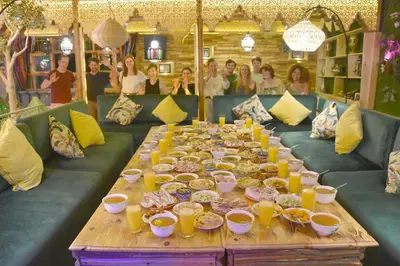 a long table with plates of food and people at Riad Verus in Fès