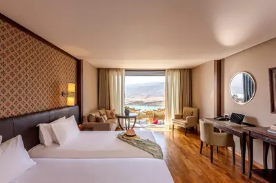 a hotel room with two beds and a desk at Widiane Resort in Bine el Ouidane