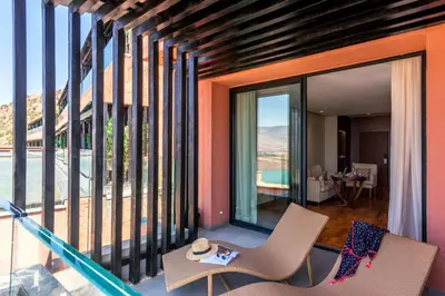 a room with two chairs and a balcony with windows at Widiane Resort in Bine el Ouidane