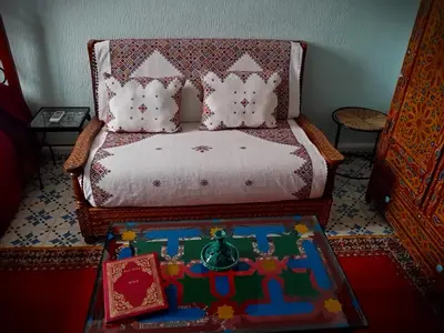 a bed with pillows and a table in a room at Riad Atika Mek in Meknès