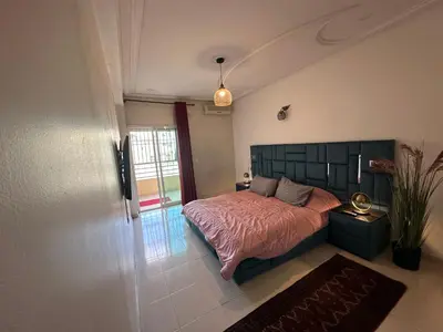 a bedroom with a bed with a pink bedspread at Sweet Jacob's Apartments in Fès