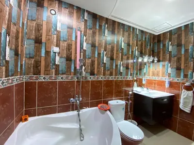 a bathroom with a tub and a toilet and a sink at Sweet Jacob's Apartments in Fès
