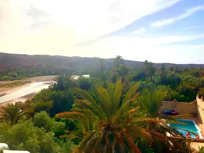 a view of a resort with a pool and palm trees at Kasbah Elmehdaoui in Skoura