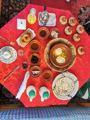 a table with plates of food on a red table cloth at Kasbah Elmehdaoui in Skoura