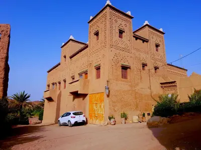 a white car parked in front of a building at Kasbah Elmehdaoui in Skoura
