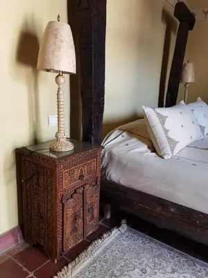 a lamp on a night stand next to a bed at Palais didi in Meknès