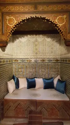 a bench with pillows on a wall in a room at Palais didi in Meknès