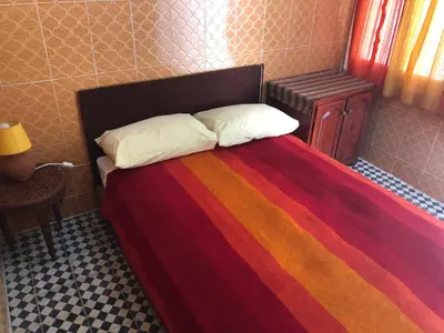 a bed with a multicolored blanket and two pillows at Youth Hostel International Fez in Fès