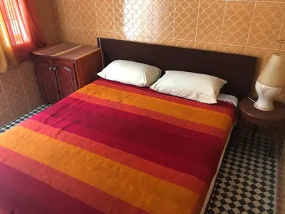 a bed with a multicolored blanket and two pillows at Youth Hostel International Fez in Fès