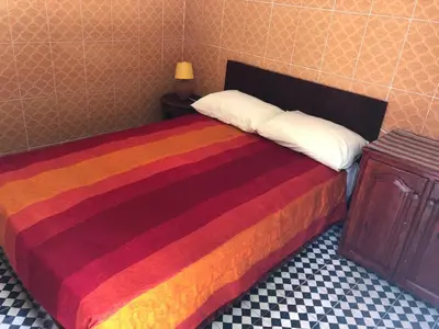 a bed with a colorful blanket and a night stand at Youth Hostel International Fez in Fès