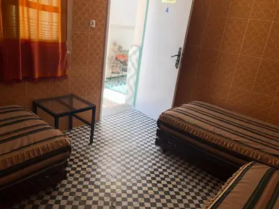 a room with two beds and a tiled floor at Youth Hostel International Fez in Fès