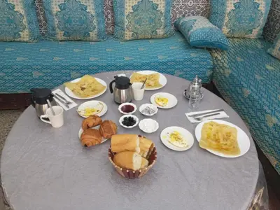 a table topped with plates of food and bread at Youth Hostel International Fez in Fès