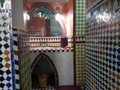 a bathroom with a tile wall and a mirror at Riad Soleil d'Or in Fès