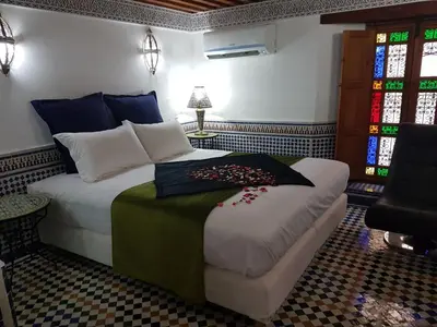 a bedroom with a bed and a stained glass window at Riad Soleil d'Or in Fès