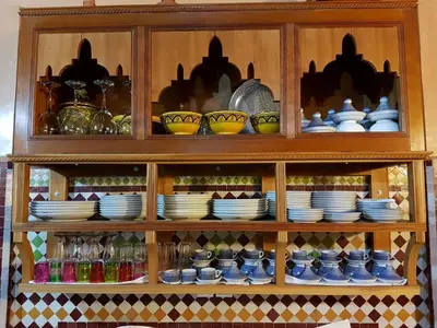 a wooden cabinet filled with dishes and plates at Riad Soleil d'Or in Fès