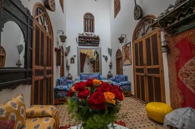 a living room with a bouquet of red roses at Riad Les Idrissides Chez LEA in Fès