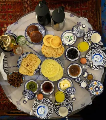 a table topped with plates of food and drinks at Riad Les Idrissides Chez LEA in Fès