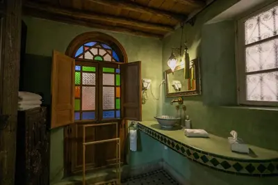 a bathroom with a sink and a stained glass window at Riad Les Idrissides Chez LEA in Fès