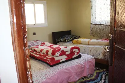 a room with two beds and a window at Auberge Toubkal Amsouzart Aitst Idar in Tizgui