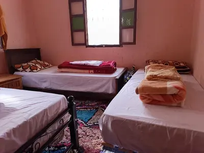 a room with three beds and a window at Auberge Toubkal Amsouzart Aitst Idar in Tizgui