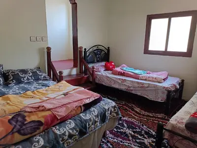 a room with two beds and a window at Auberge Toubkal Amsouzart Aitst Idar in Tizgui