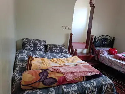 a bedroom with a bed with a blue comforter at Auberge Toubkal Amsouzart Aitst Idar in Tizgui
