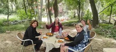a group of women sitting around a table eating food at Auberge Toubkal Amsouzart Aitst Idar in Tizgui