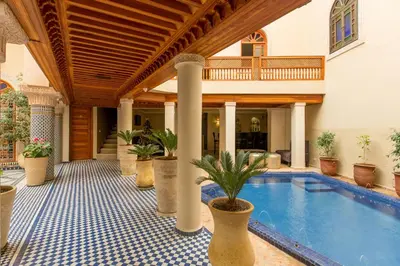 a house with a swimming pool with potted plants at Riad Andalib in Fès