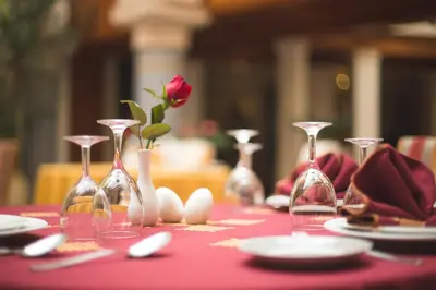 a table with wine glasses and a rose on it at Riad Andalib in Fès