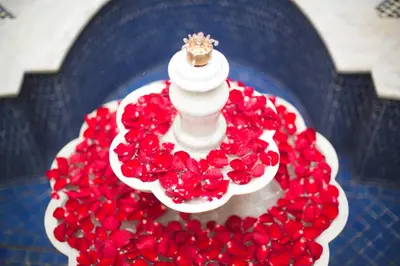 a wedding cake with red flowers on top of it at Riad Andalib in Fès
