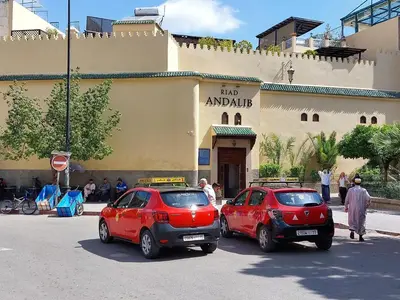 two red cars parked in front of a building at Riad Andalib in Fès