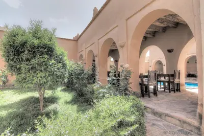 an outdoor patio of a house with a table and chairs at Kasbah Imdoukal in Nkob