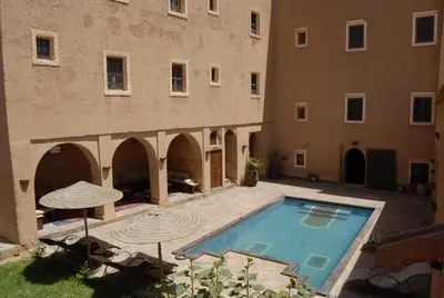 a courtyard with a swimming pool next to a building at Kasbah Imdoukal in Nkob