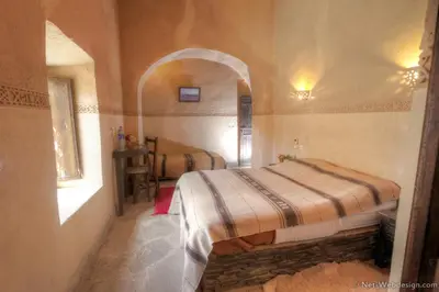 a bedroom with a bed in the corner of a room at Kasbah Imdoukal in Nkob