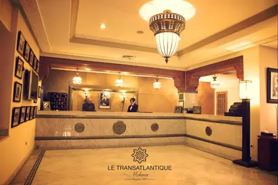 a woman standing in front of a hair salon at Hotel Transatlantique in Meknès