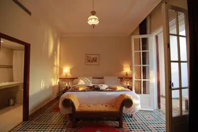 a bedroom with a bed and a large window at Hotel Transatlantique in Meknès