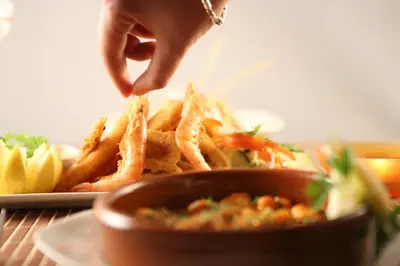 a person eating french fries and a plate of food at Hotel Transatlantique in Meknès