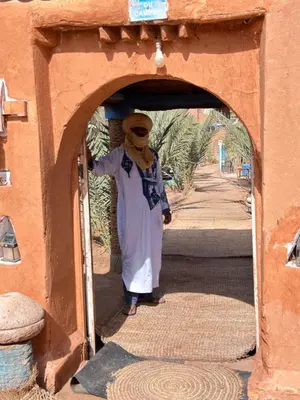 a woman standing in an archway of a building at Auberge L'Oasis Mhamid in Mhamid