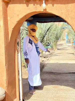 a woman wearing a hijab standing in a doorway at Auberge L'Oasis Mhamid in Mhamid