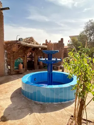 a blue fountain in the middle of a yard at Auberge L'Oasis Mhamid in Mhamid