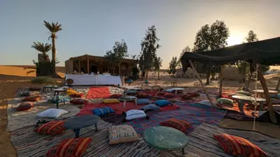 a group of umbrellas and pillows on a beach at SaharaTime Camp in Hassilabied
