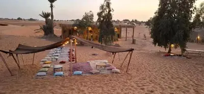 a group of hammocks in the middle of the desert at SaharaTime Camp in Hassilabied