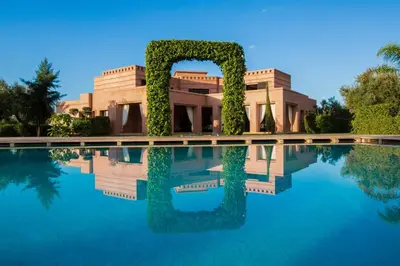 a villa with a swimming pool in front of it at Villa Koutoubia, jardin luxuriant, piscine et spa in Marrakech