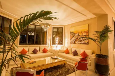 a living room with a couch and a table at Villa Koutoubia, jardin luxuriant, piscine et spa in Marrakech