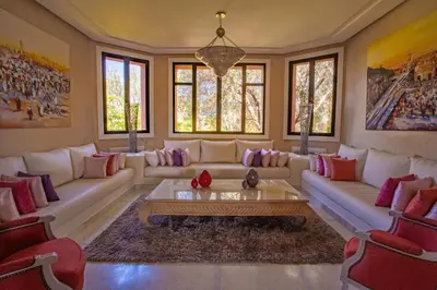 a living room with a couch and a table at Villa Koutoubia, jardin luxuriant, piscine et spa in Marrakech