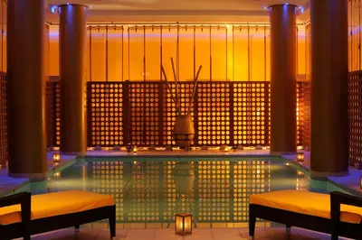a pool in a building with two chairs and lights at Palais Medina Riad Resort in Fès