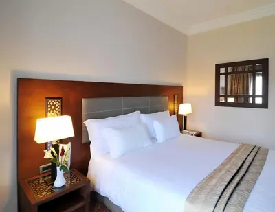 a bedroom with a large white bed and two lamps at Palais Medina Riad Resort in Fès