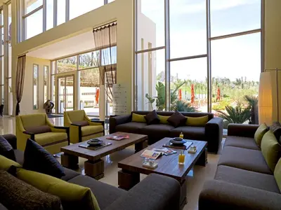 a living room with couches and tables and large windows at Palais Medina Riad Resort in Fès